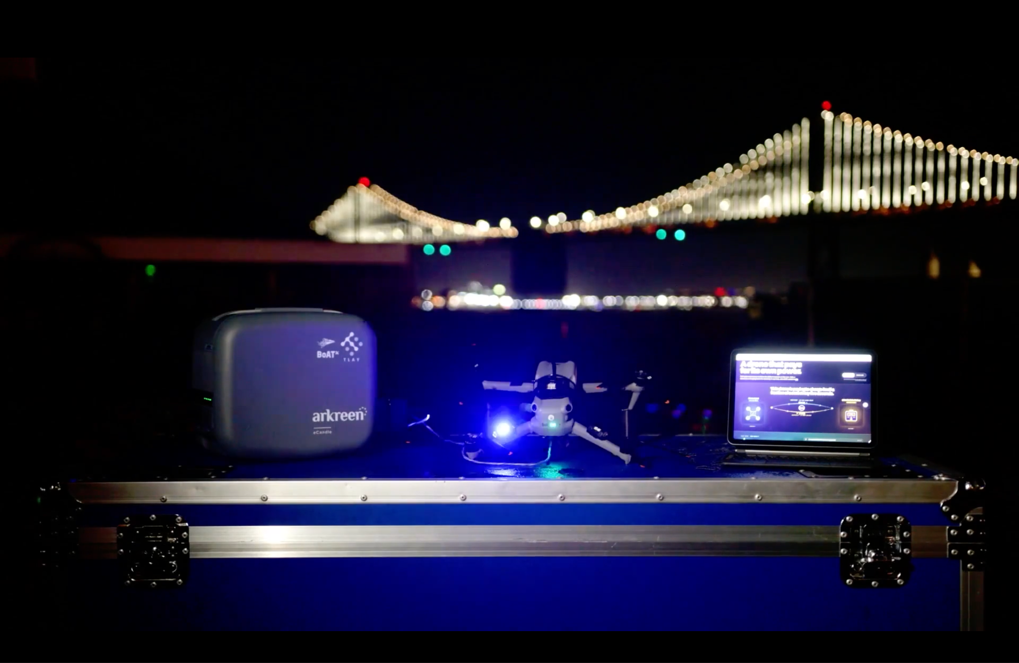 The demo setup at night: an Arkreen eCandle, the drone and the live payment interface, with the Bay Bridge behind